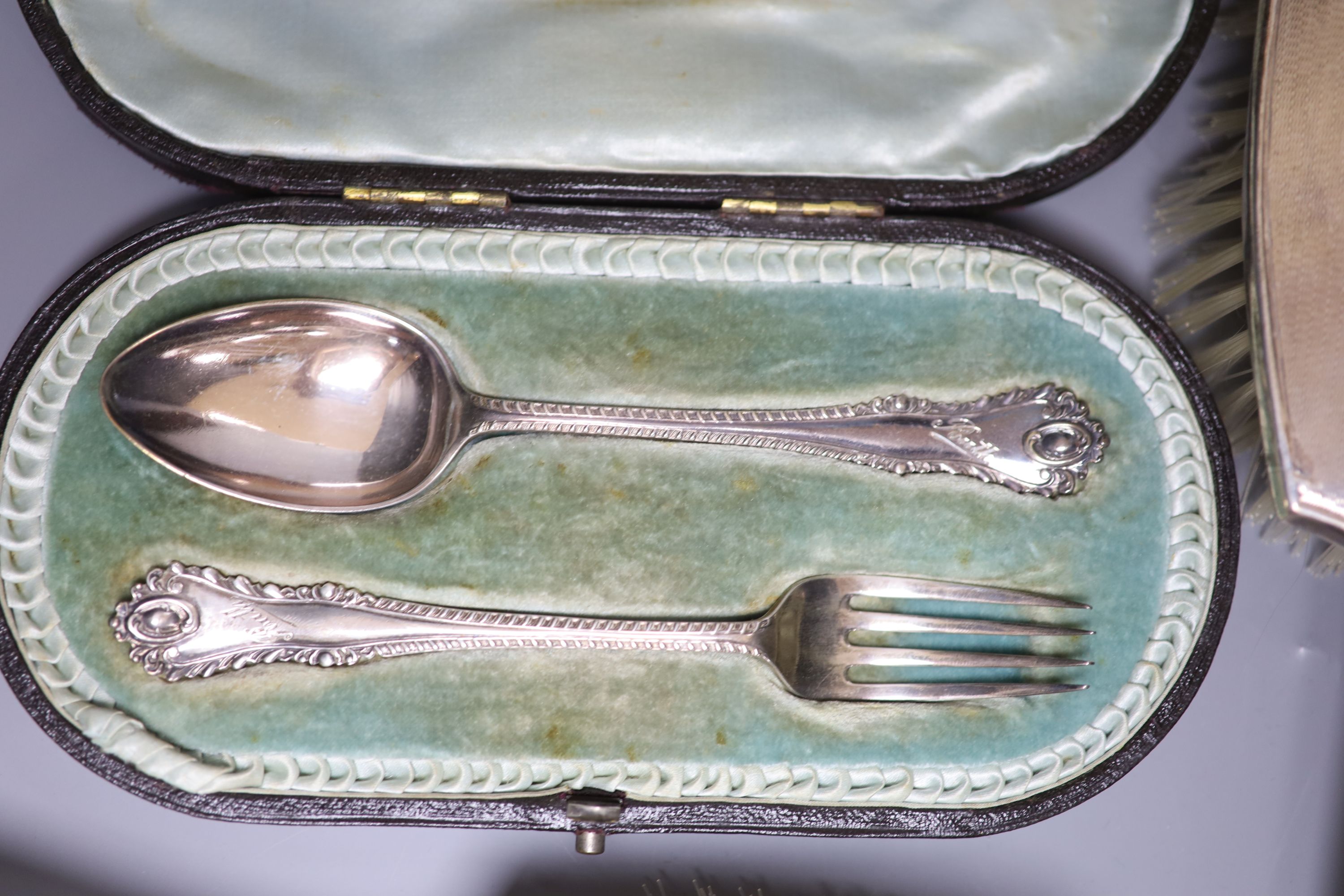 A George V Arts & Crafts silver baluster sugar caster, by Albert Edward Jones, 14.8cm, cased, a five-piece engine-turned dressing table set and two cased Christening sets